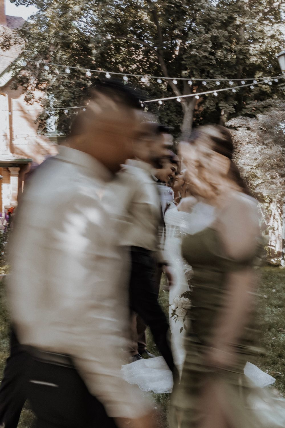 Bride and groom share a loving look as wedding party moves around them