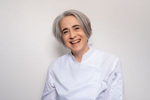 A series of headshots showing someone with silver hair wearing a white button-up shirt against a light background.