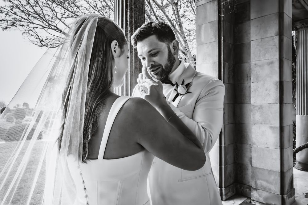 A series of black and white wedding photos showing intimate moments between a couple at an elegant venue.
