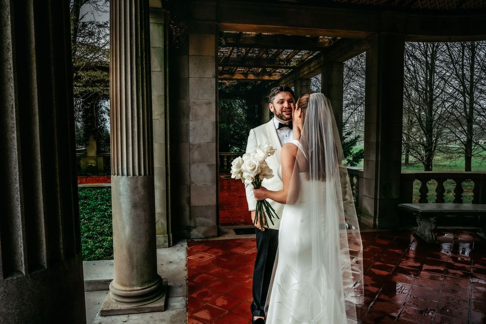 A collection of wedding portraits captured under stone columns with a bride in a flowing white gown.