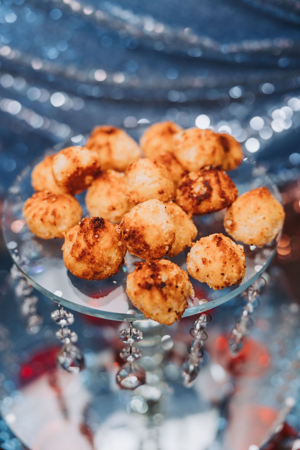 Macro shot of golden fried shrimp against a blurred blue background with bokeh light effects.