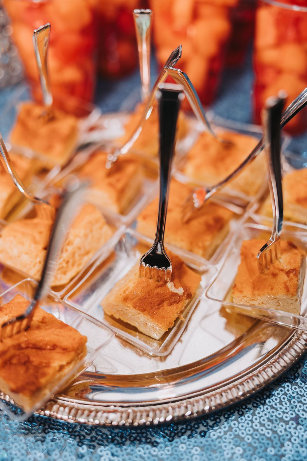 Small pastry bites served on elegant silver platters with decorative metal picks for an upscale catered event.