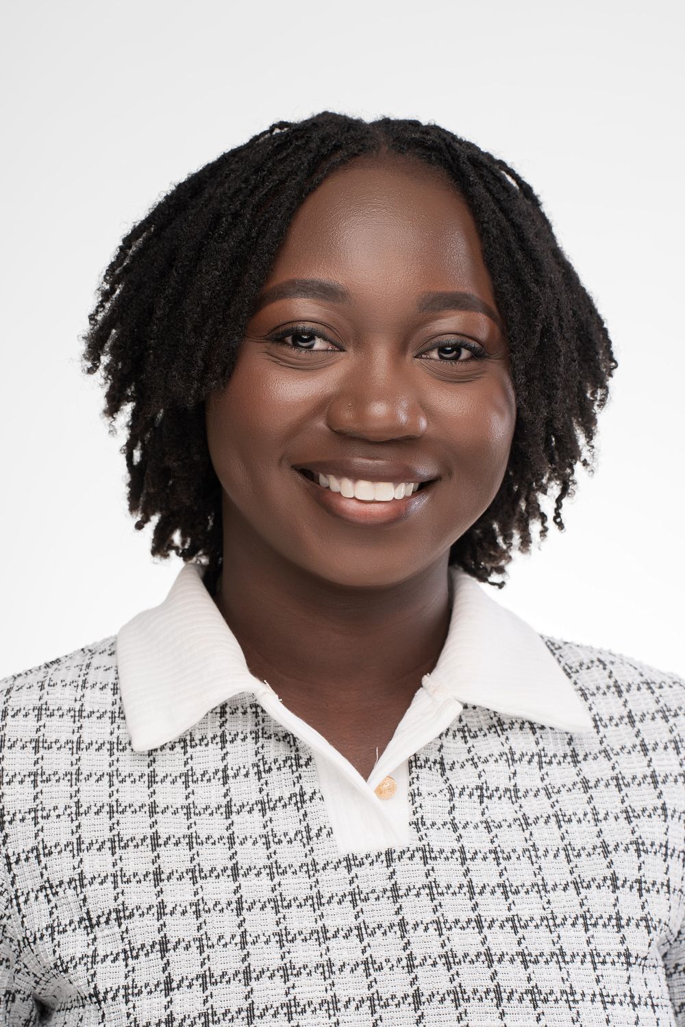 Professional headshot portraits showing bright smile wearing white patterned blazer against light background.