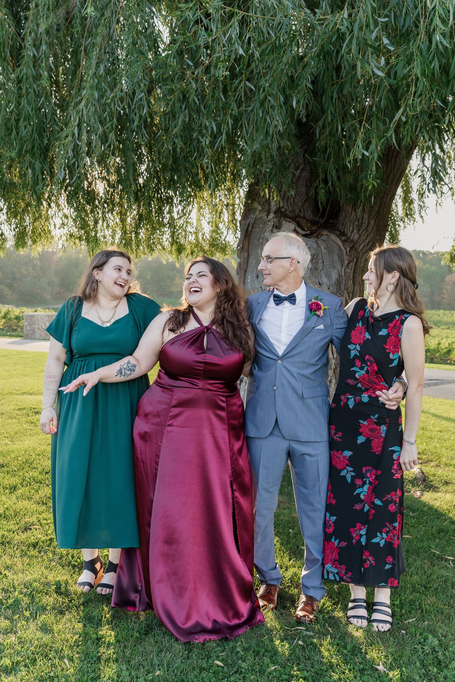 Candid group photo with groom and his daughters laughing under the willow tree at Vineland Estates Winery.