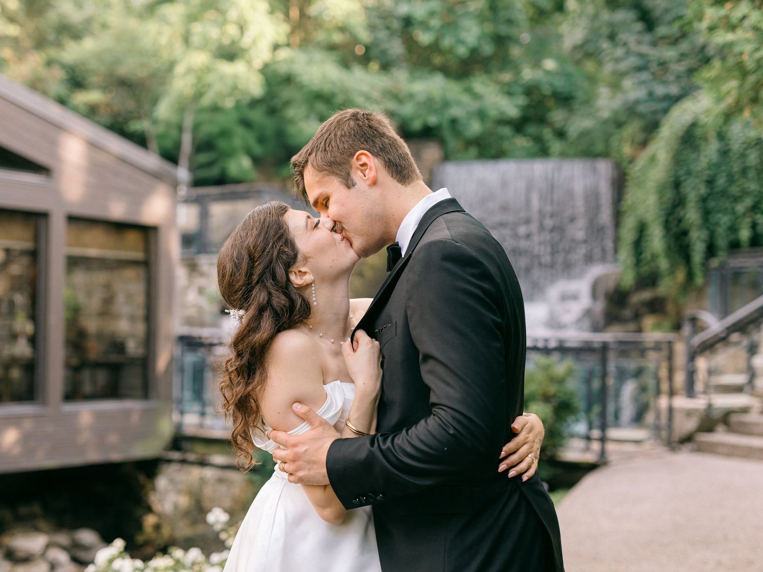 Romantic wedding couple embracing in a rustic outdoor setting.