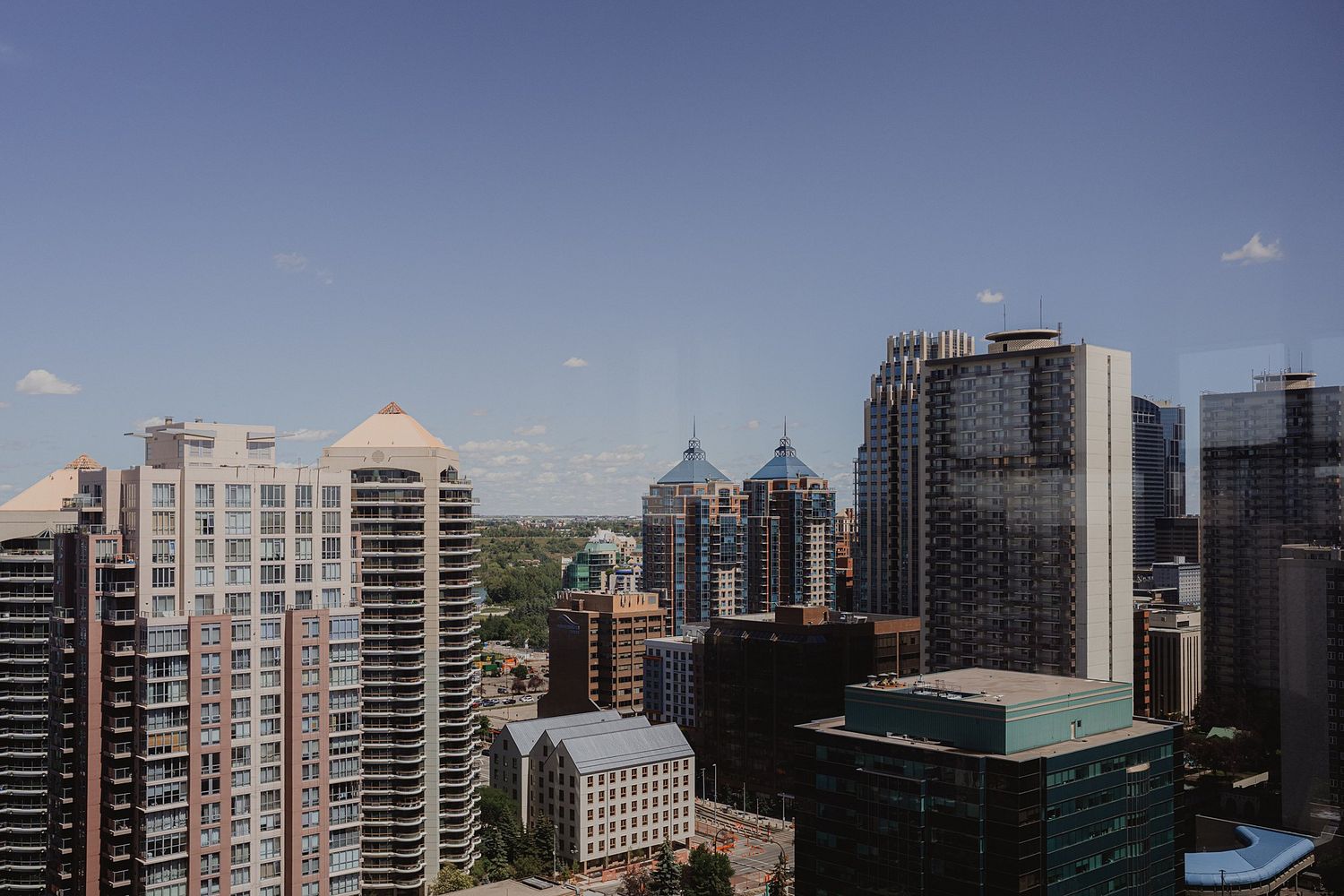Modern city skyline with high-rise buildings and skyscrapers against a blue sky in an urban downtown setting.