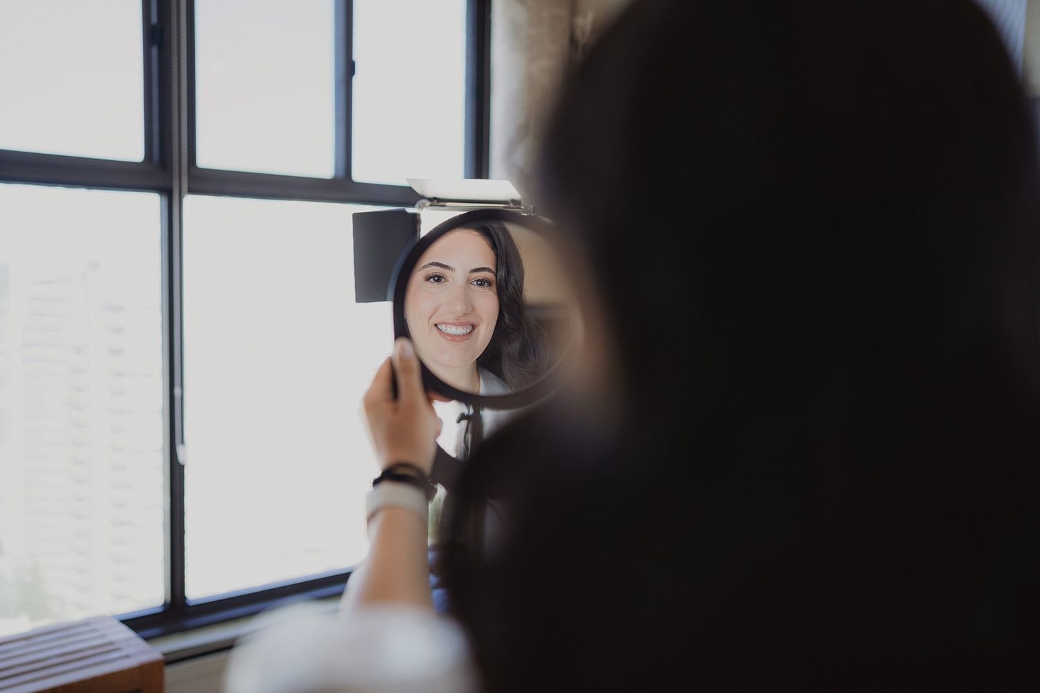 Natural light streams through windows during intimate wedding preparation moments.