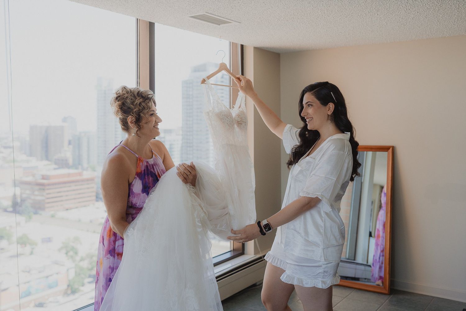 Wedding dress preparations in a sunlit room with multiple gowns visible.