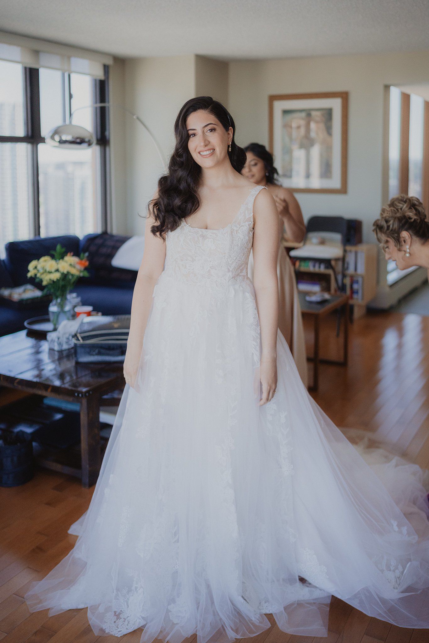 Close-up details of a flowing white wedding gown with delicate lace and tulle fabric.