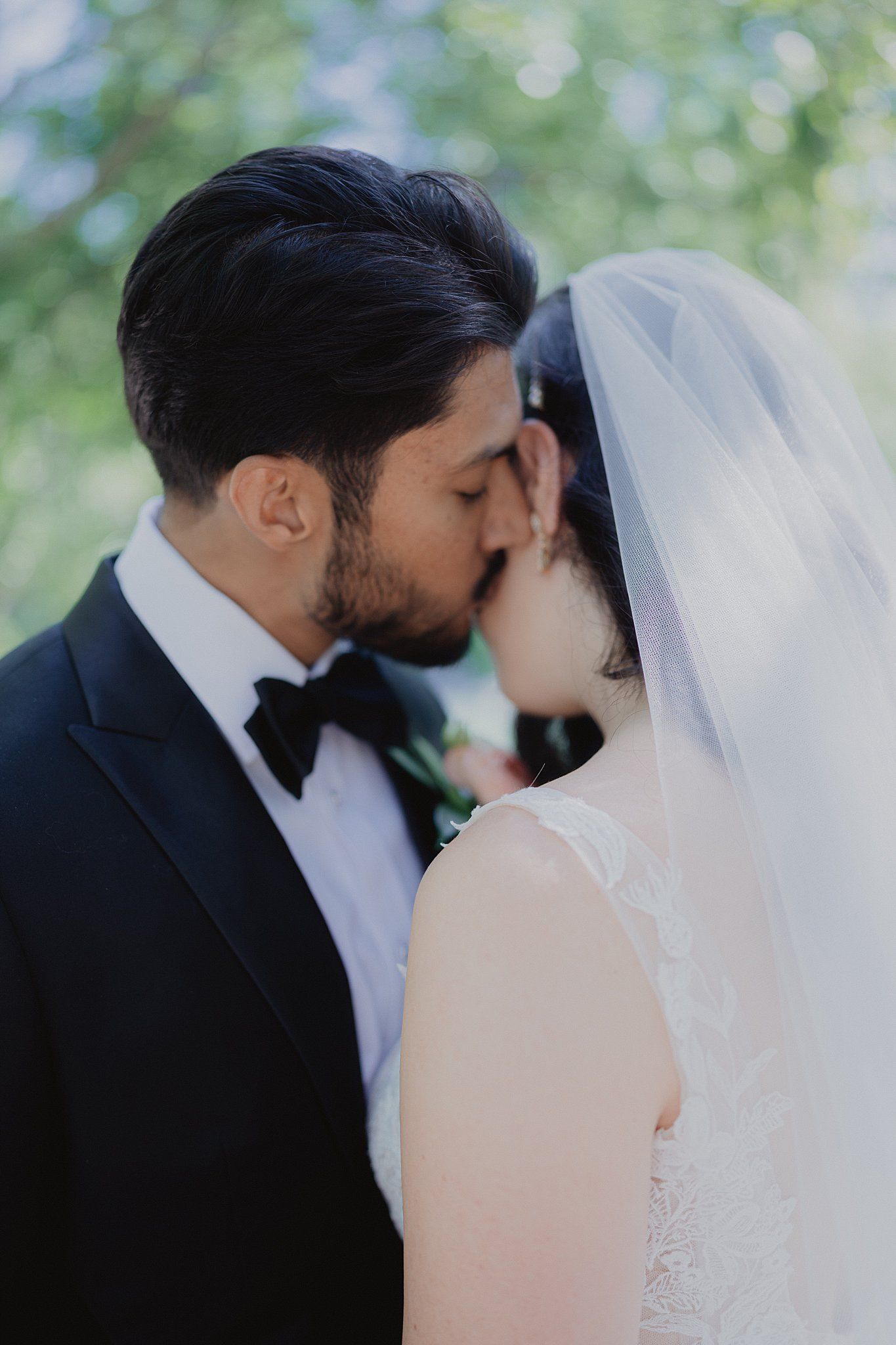 Romantic wedding ceremony moment captured in a garden setting with natural bokeh.