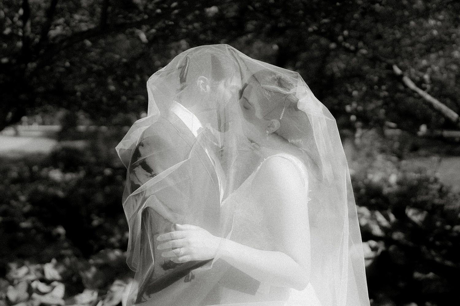 Close-up details of a flowing white wedding dress with intricate fabric texture.
