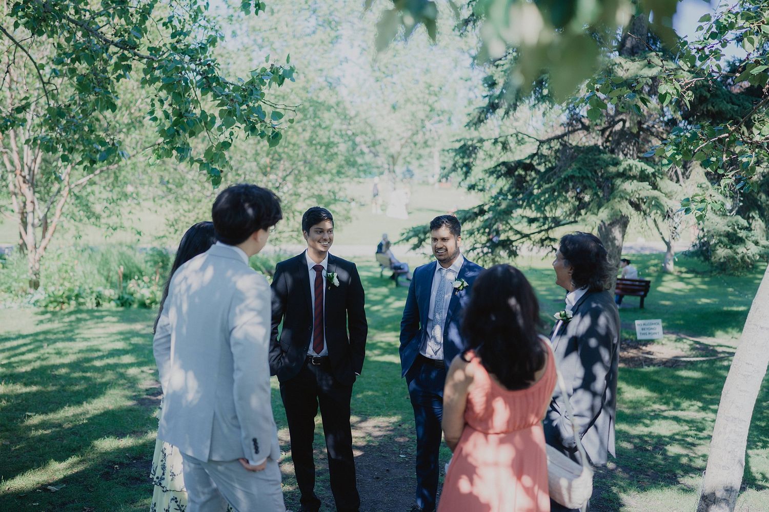 Small wedding gathering in a peaceful garden setting surrounded by trees.