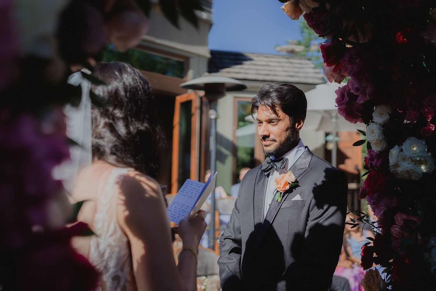 Outdoor wedding ceremony with guests gathered under natural lighting.