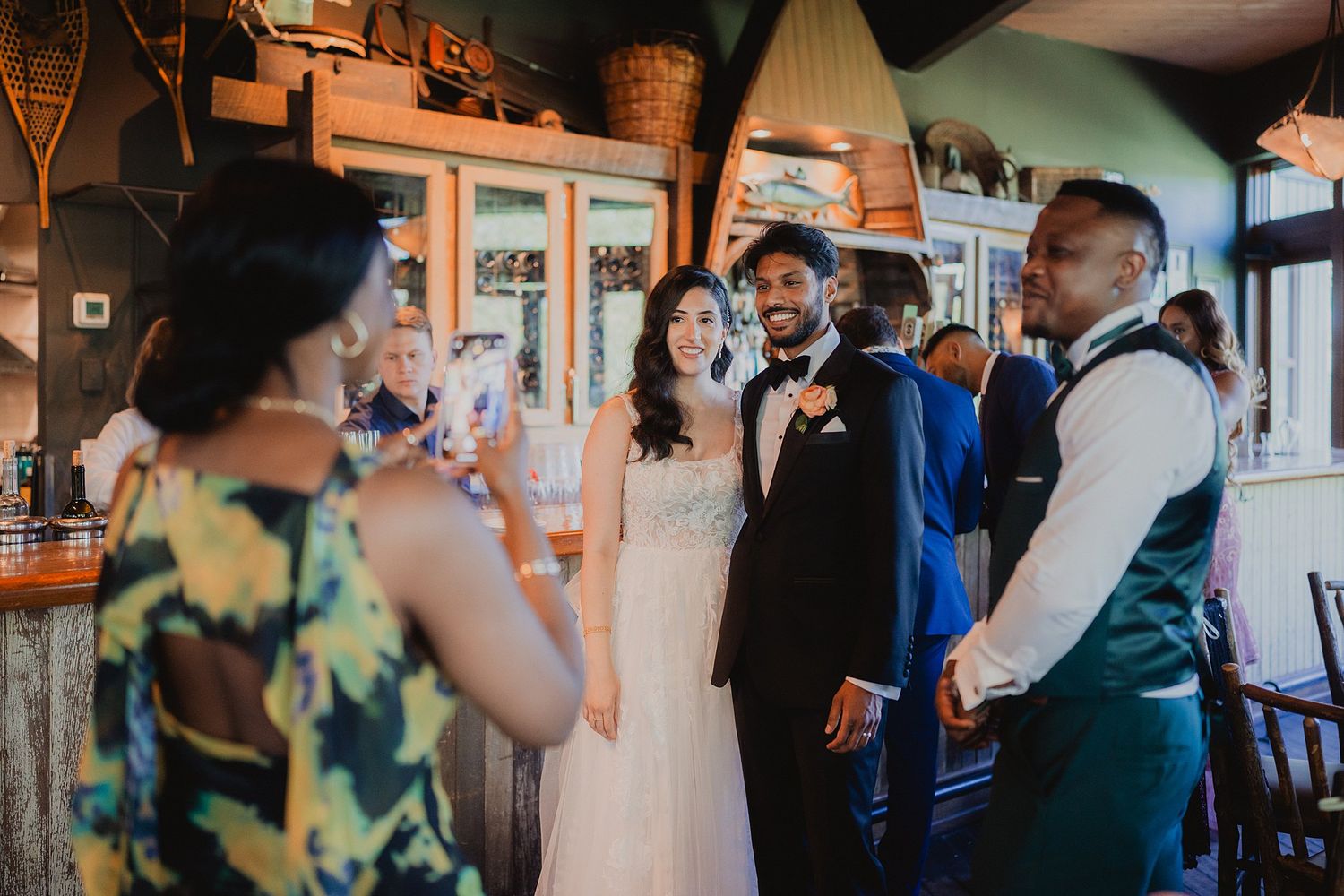 Wedding celebration inside a rustic venue with guests mingling and toasting.