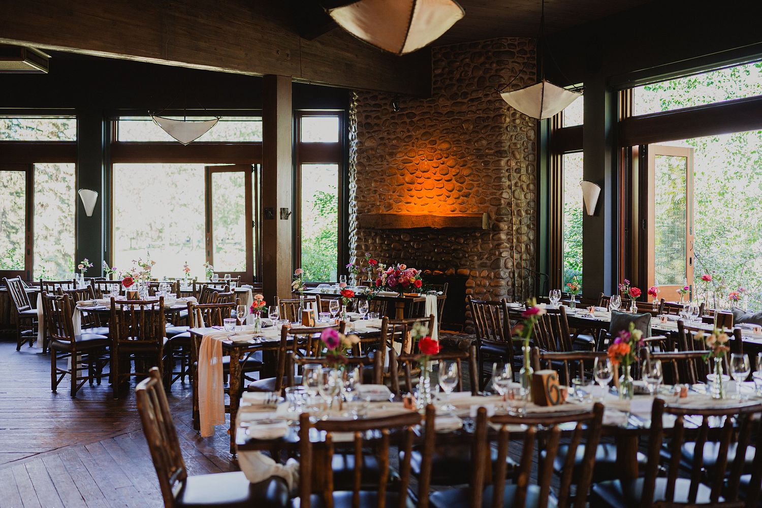 Elegant wedding reception venue with rustic brick walls and natural lighting through large windows.