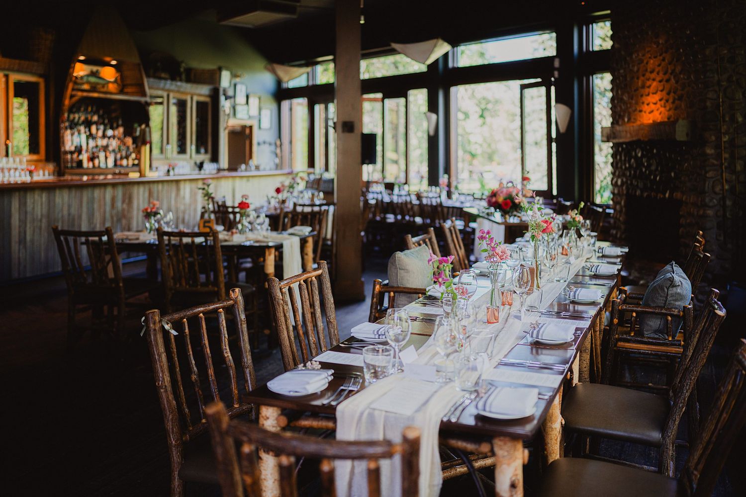 Elegant wedding reception table settings in a dimly lit restaurant venue.