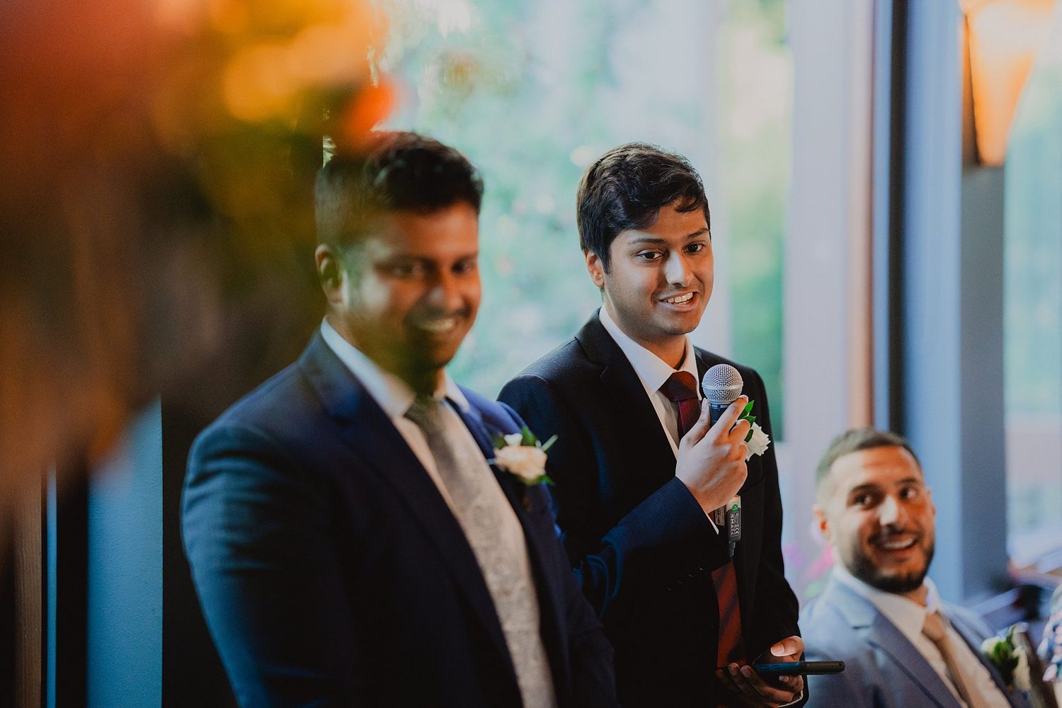 Wedding guests and speakers share heartfelt toasts during an elegant indoor reception.
