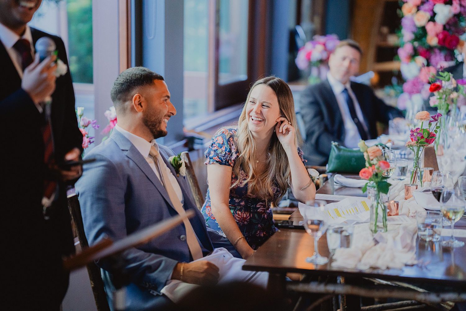 Wedding guests enjoying conversation at elegantly decorated reception tables.
