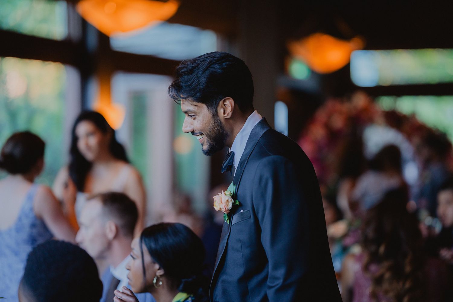 Wedding guest in formal attire mingles during an evening reception.