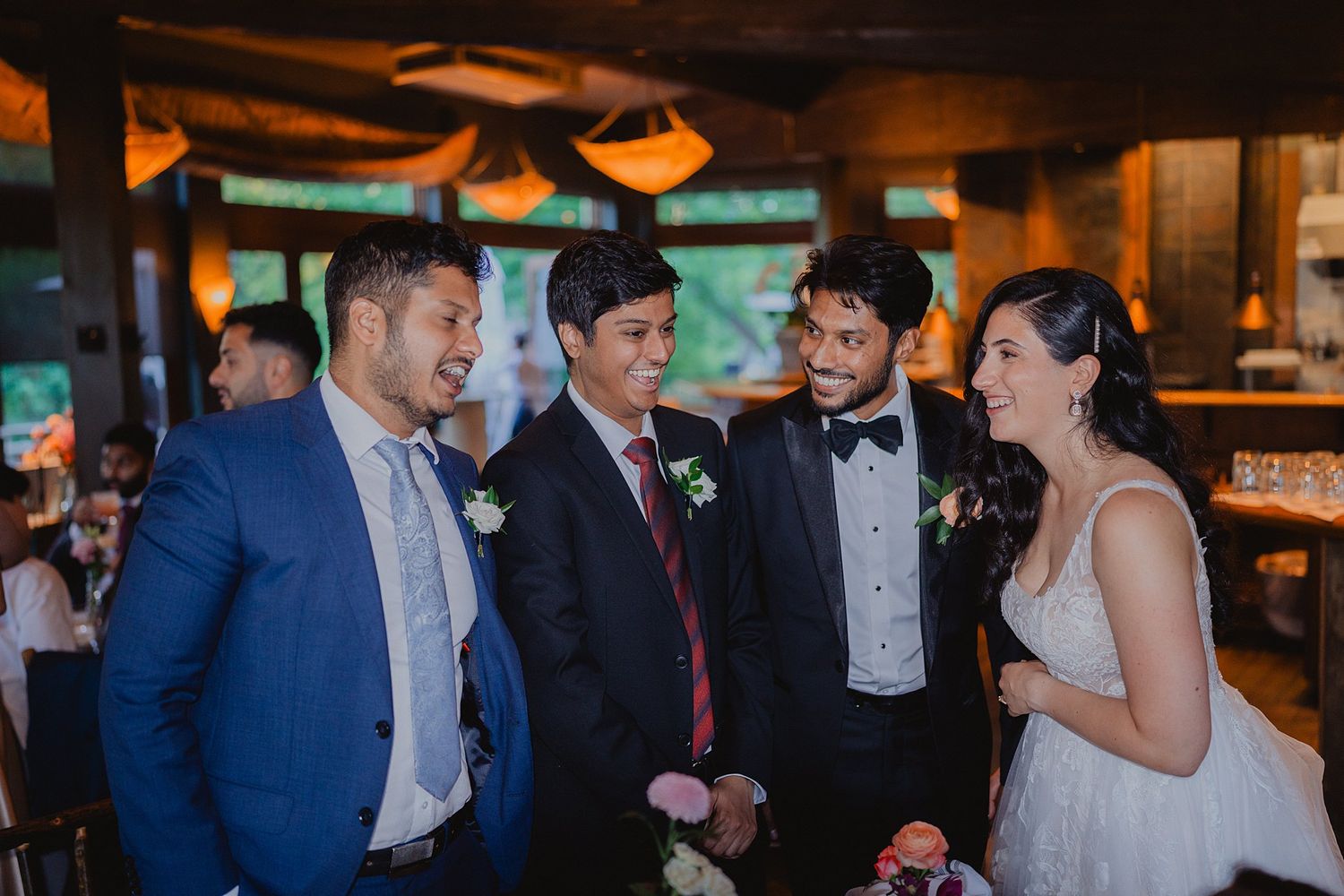 Wedding party in formal attire poses together during indoor celebration.
