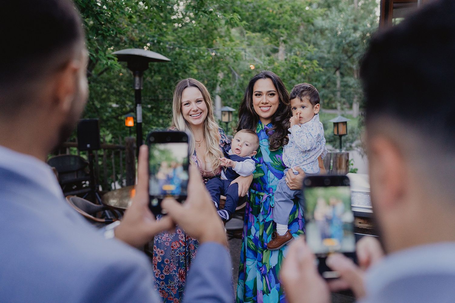 Wedding guests pose for photos in an outdoor garden setting.