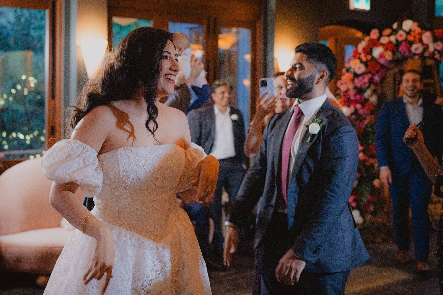 Wedding celebration features dancing and festivities in rustic indoor venue.