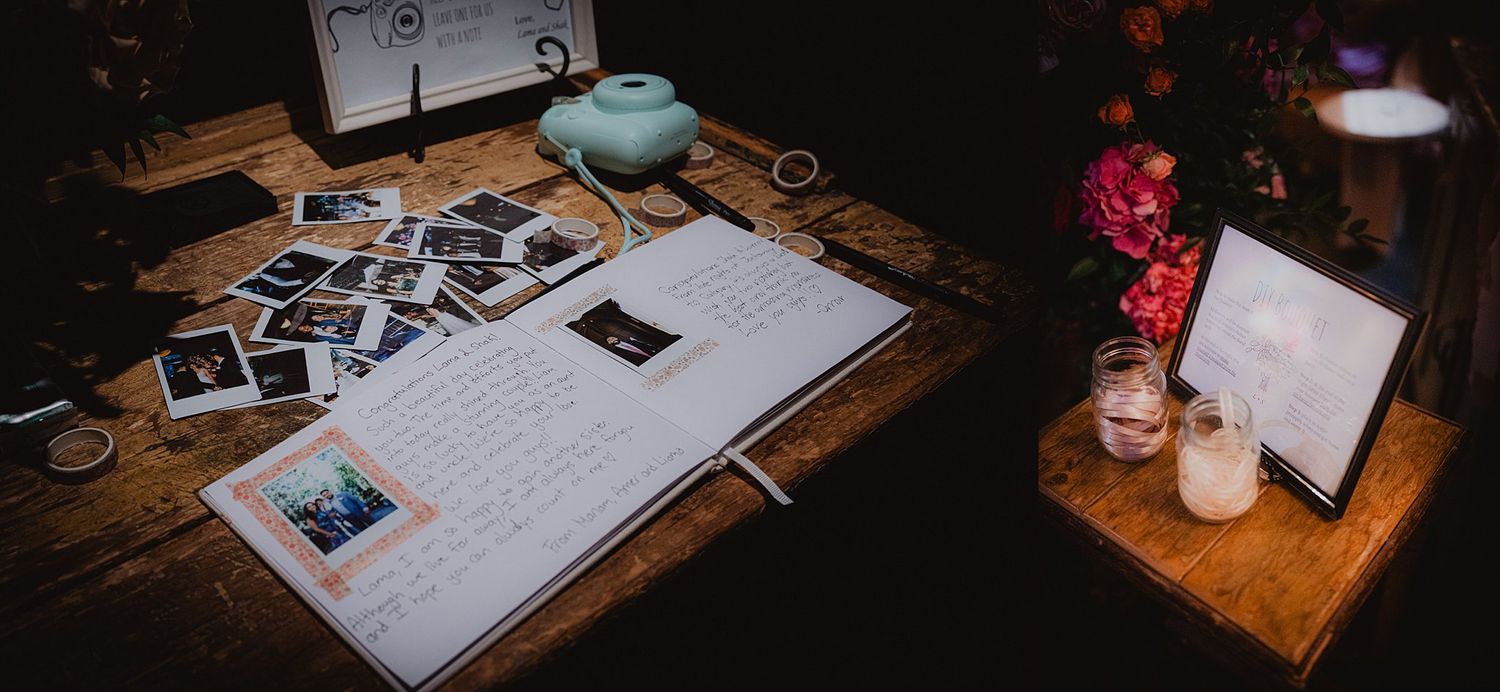 A wedding guest book and decorative items displayed on a rustic wooden table with ambient lighting.