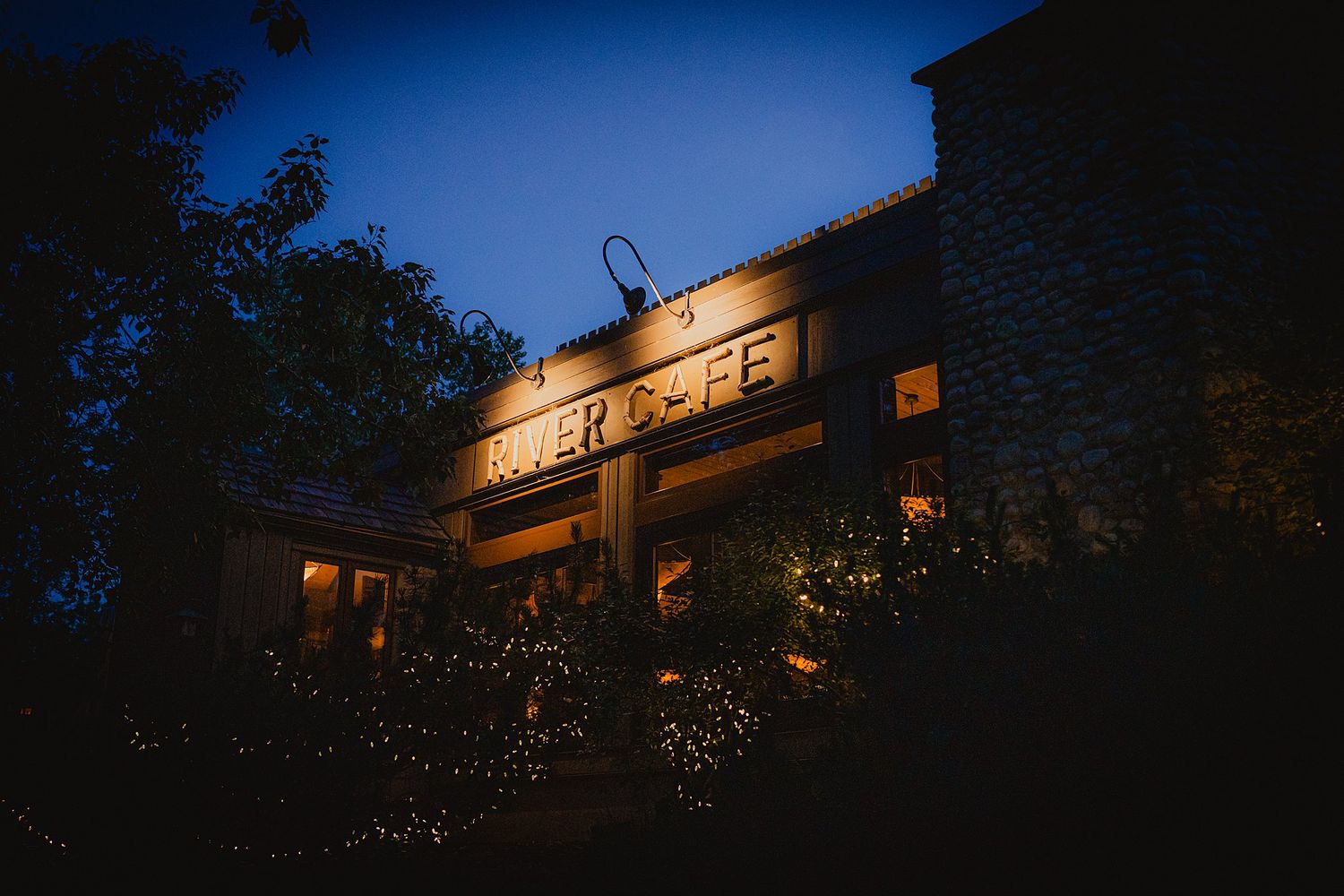 Exterior nighttime view of a venue with illuminated windows against a deep blue sky.