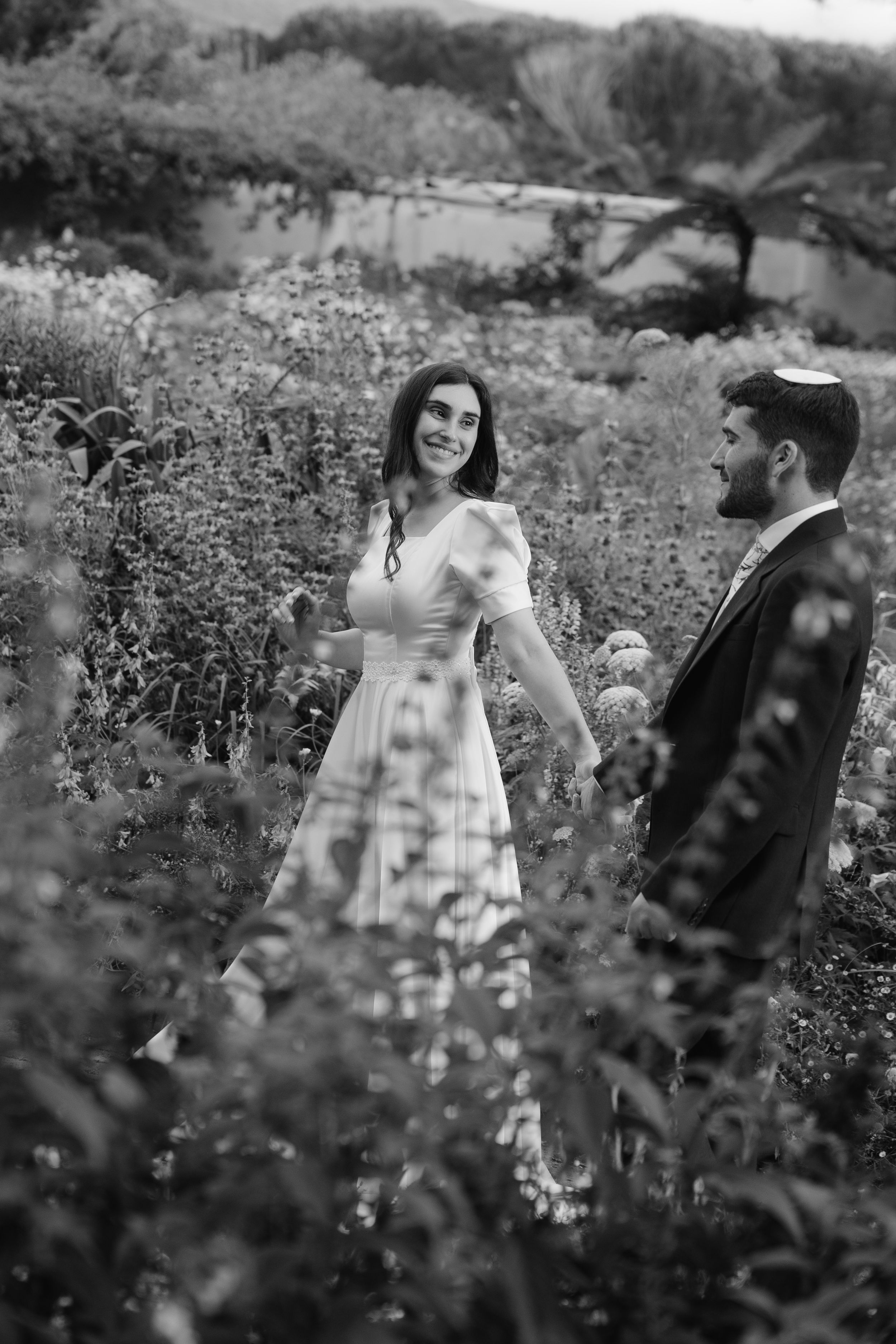 A couple shares a romantic moment together in a wildflower meadow on a sunny afternoon.