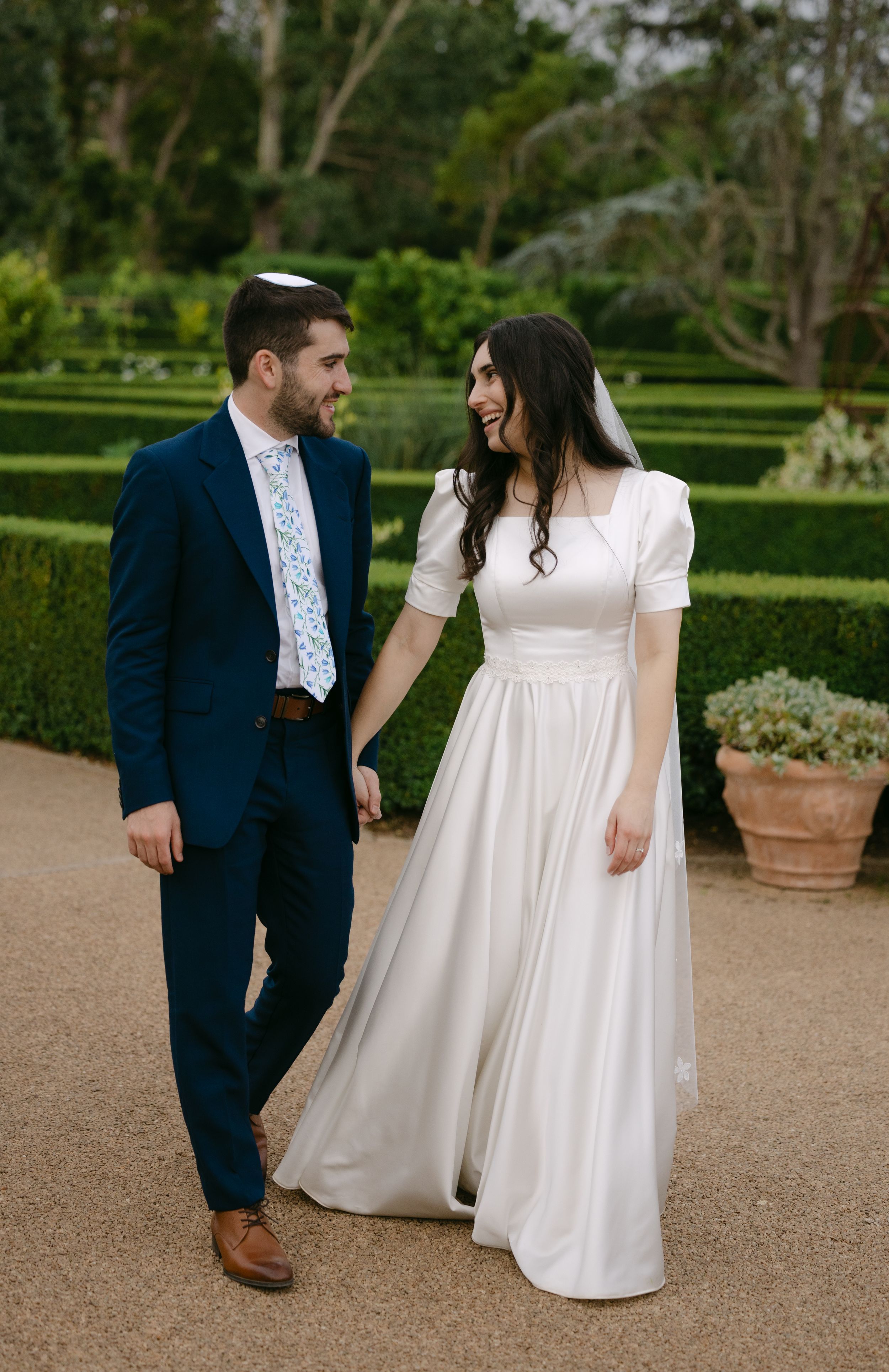 A couple in wedding attire share intimate moments in a garden setting across a series of romantic photos.