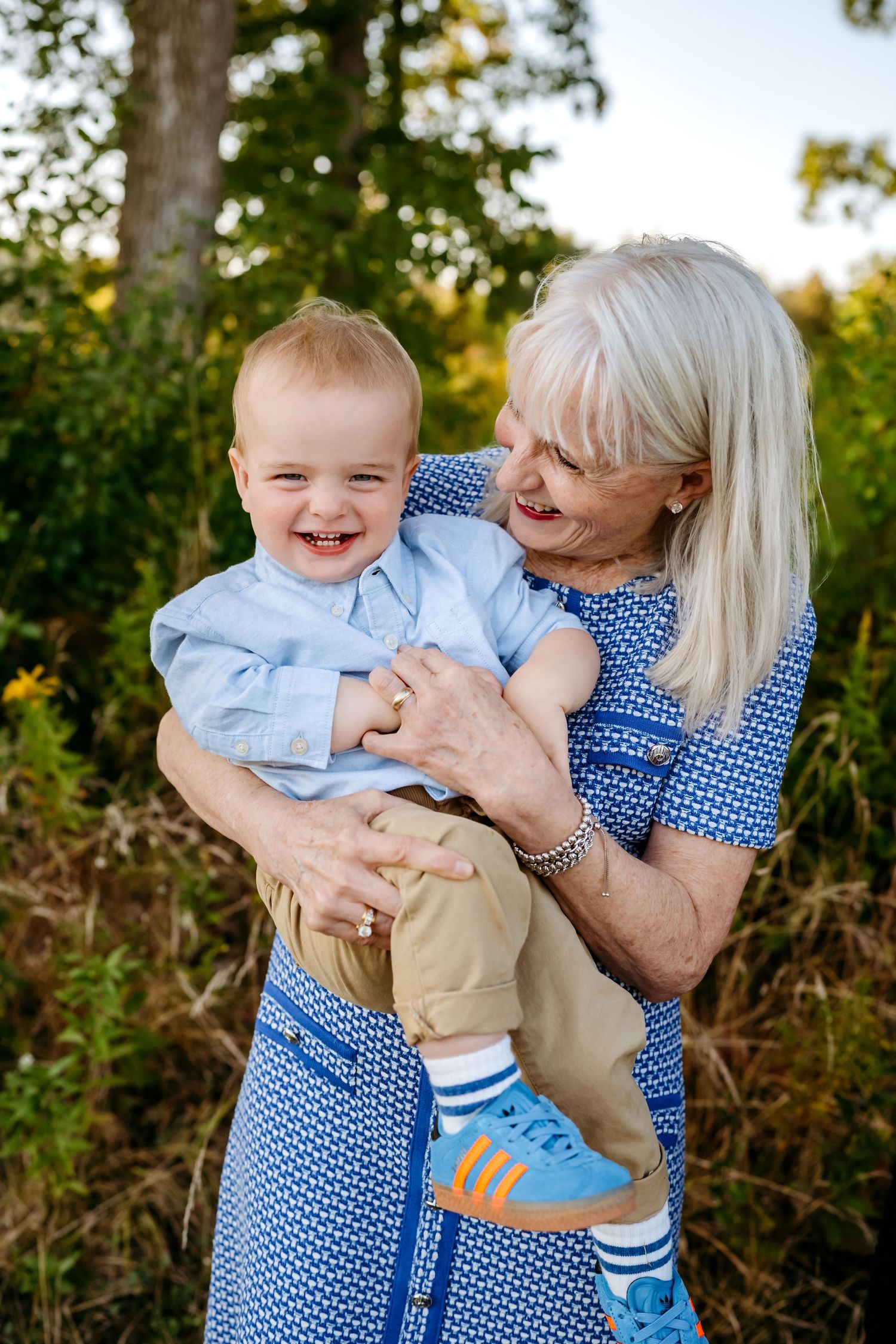 A joyful moment shared between generations as they embrace outdoors in matching blue outfits during golden hour.