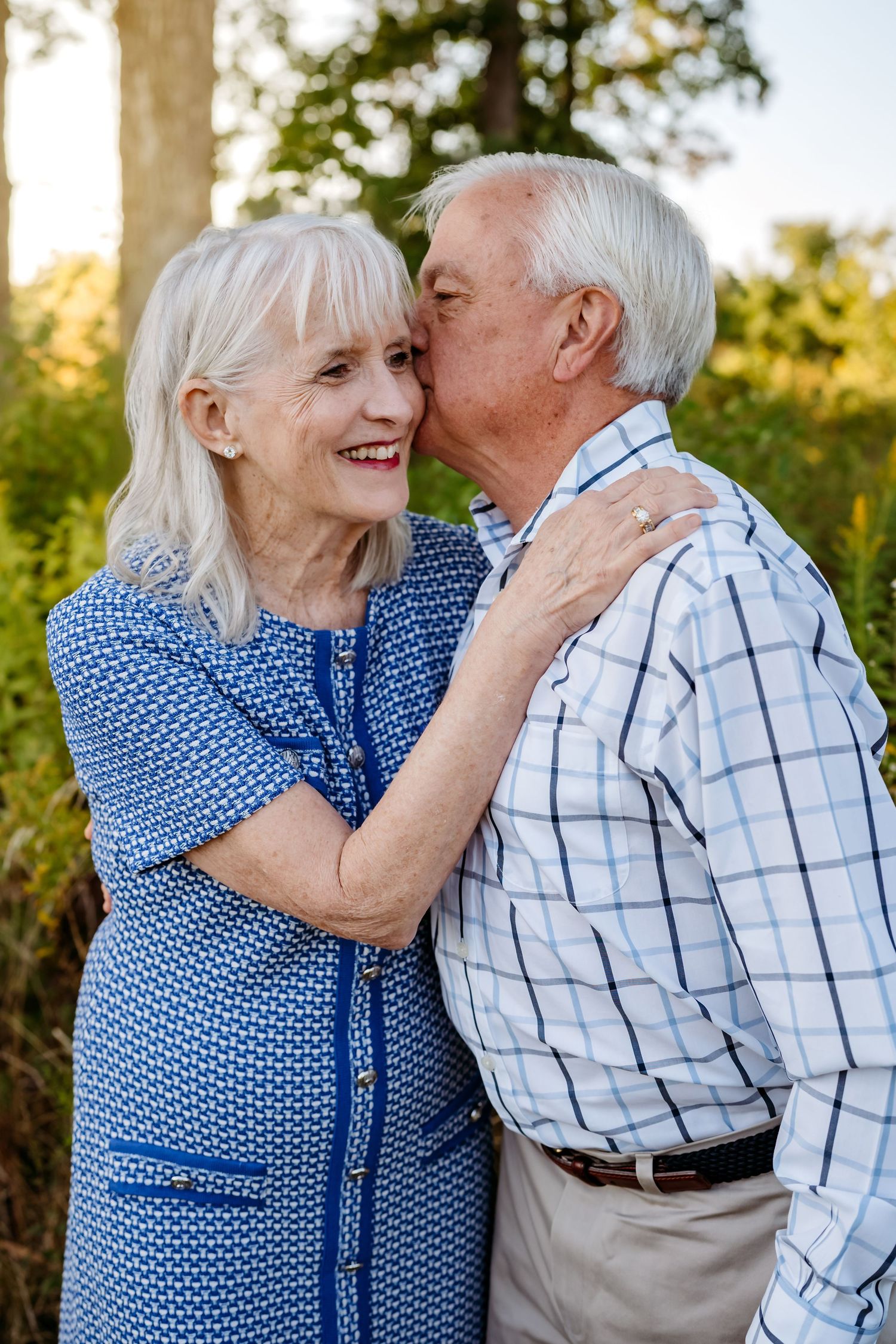 Elderly couple in blue and plaid sharing tender moments together in a series of romantic outdoor photos.