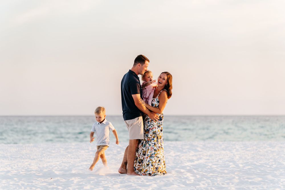 Candid family photography session capturing sweet interactions on a pristine beach at dusk.