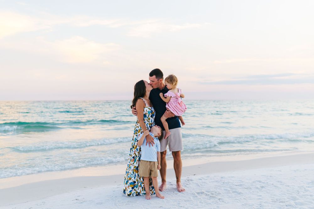 Beautiful beach family portraits with natural poses against ocean backdrop during golden hour.