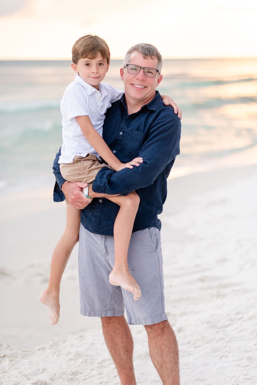 A playful beach scene at sunset with people enjoying quality time together in the sand.