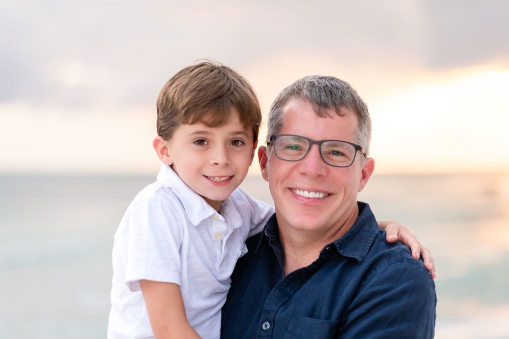 A heartwarming beach portrait showing two people embracing during golden hour.