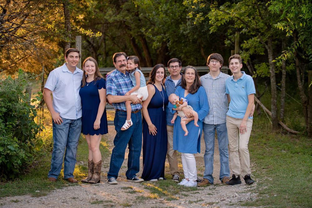 A series of outdoor family portraits taken in a natural setting with trees and autumn foliage in the background.