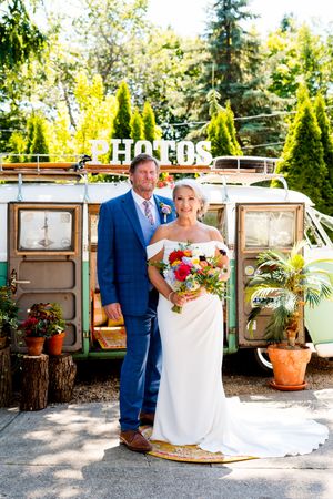 A wedding couple poses in front of vintage wooden doors in an outdoor garden setting.