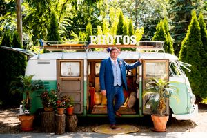 A rustic outdoor wedding venue with vintage furniture and decor pieces arranged in a garden setting.
