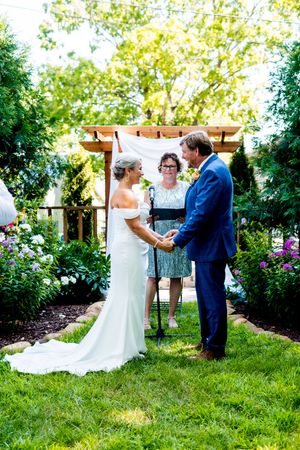 A romantic garden wedding ceremony with rustic wooden decor and lush greenery.