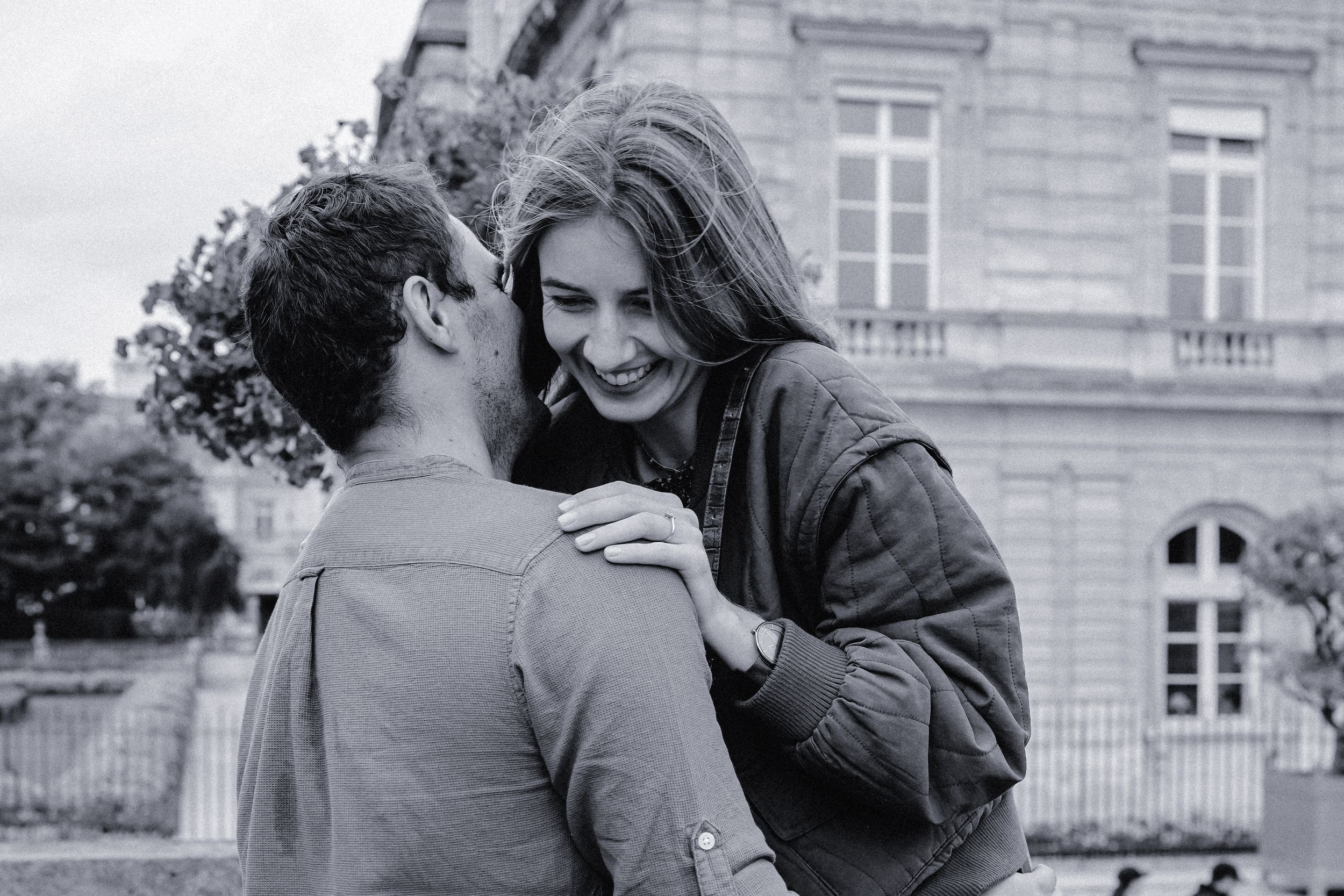 Couple sharing a joyful moment together in a classic black and white photograph.