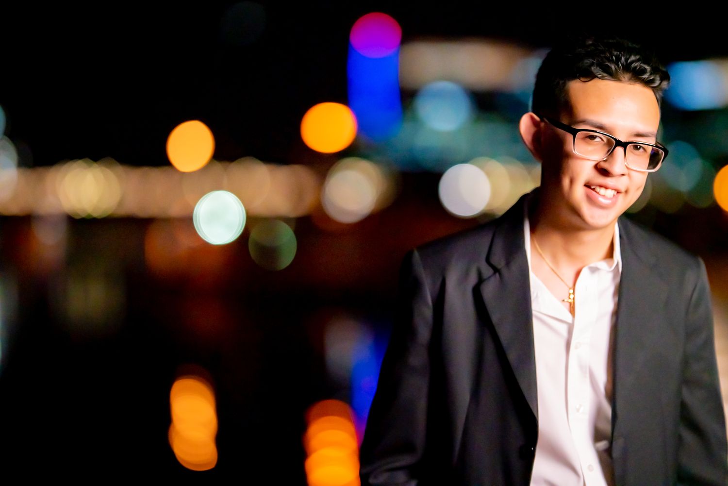 Professional portrait at night with colorful bokeh lights in the background.