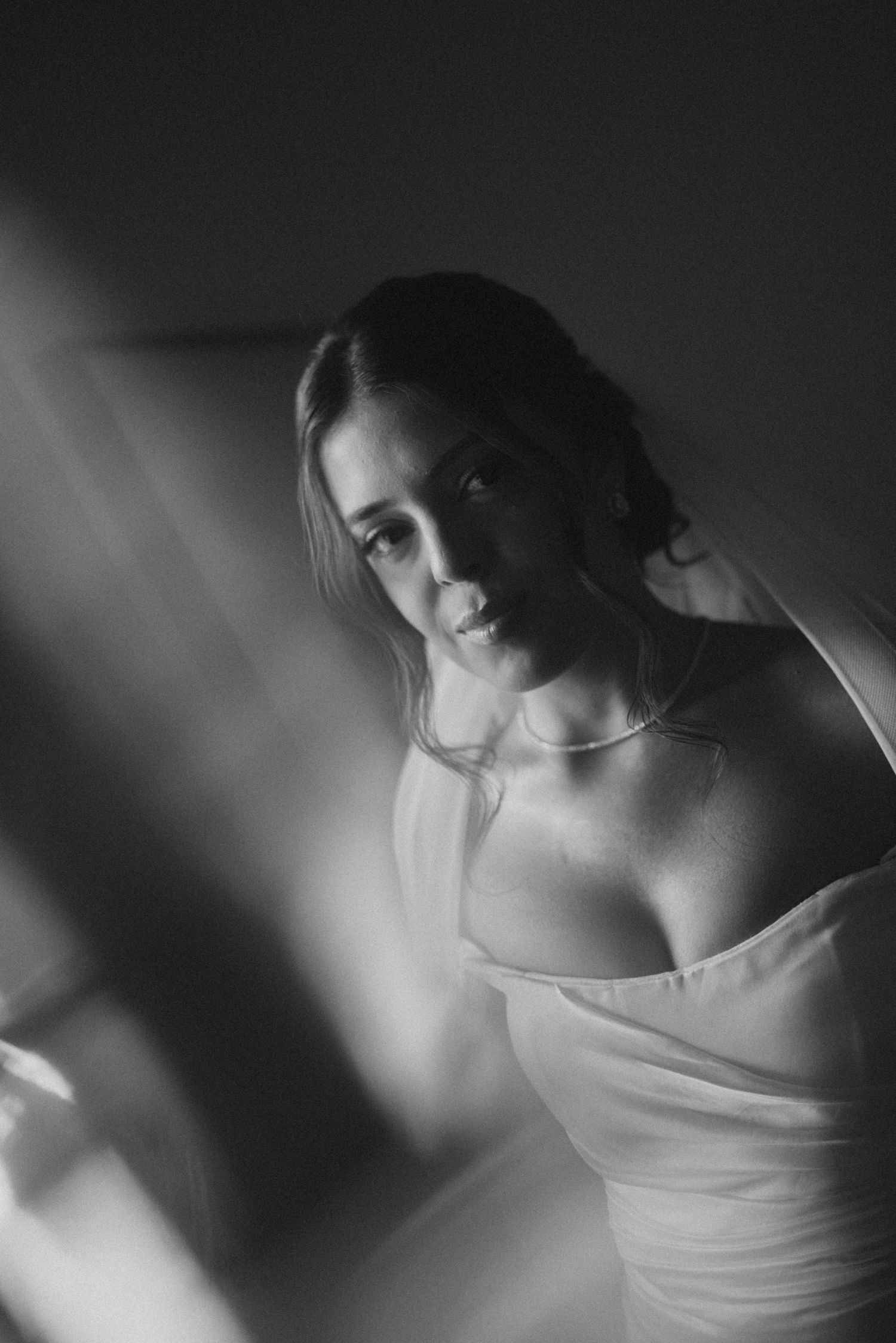 Intimate black and white bridal portrait with soft lighting and romantic atmosphere.