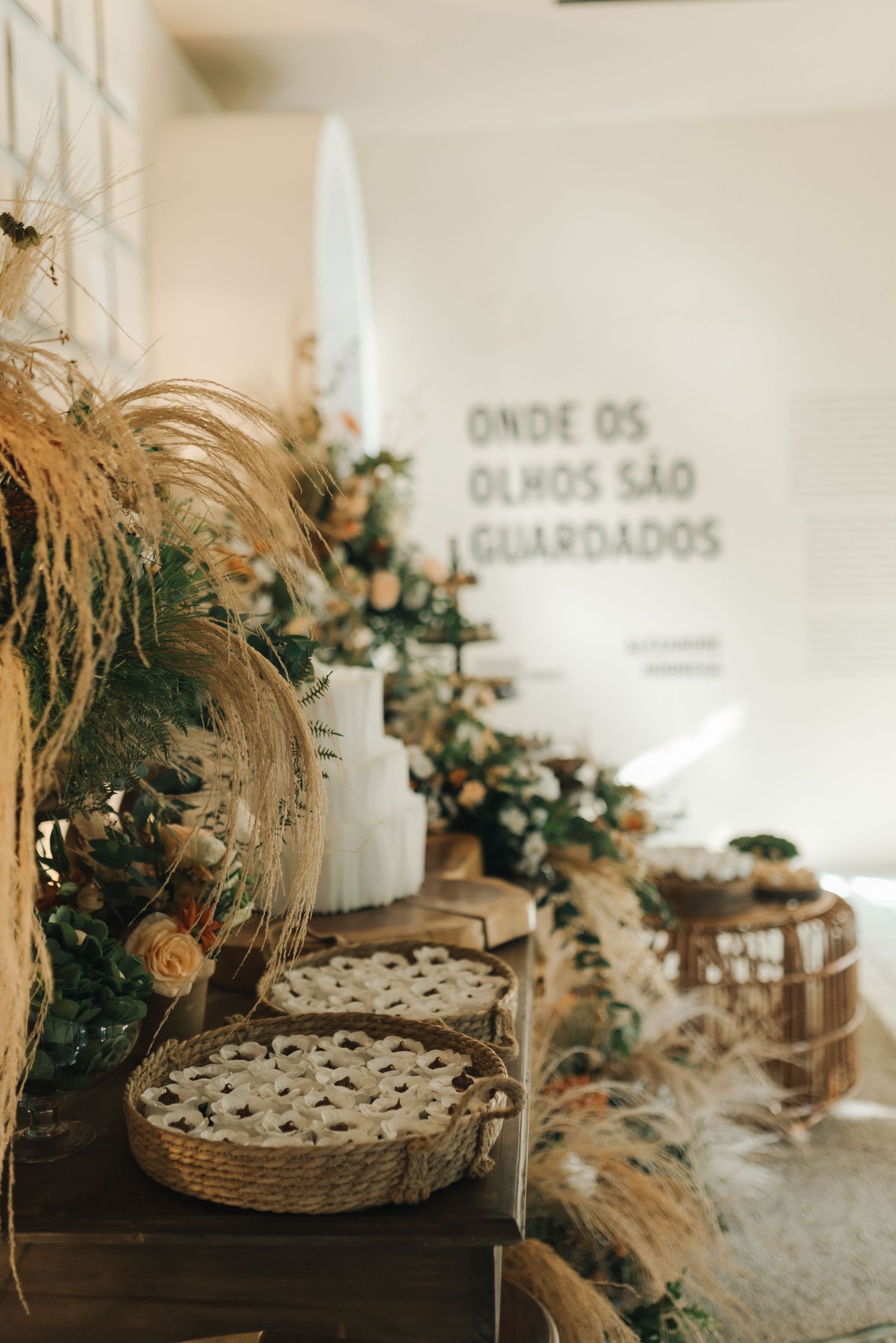 Rustic wedding dessert display featuring pies and floral decorations in warm lighting.