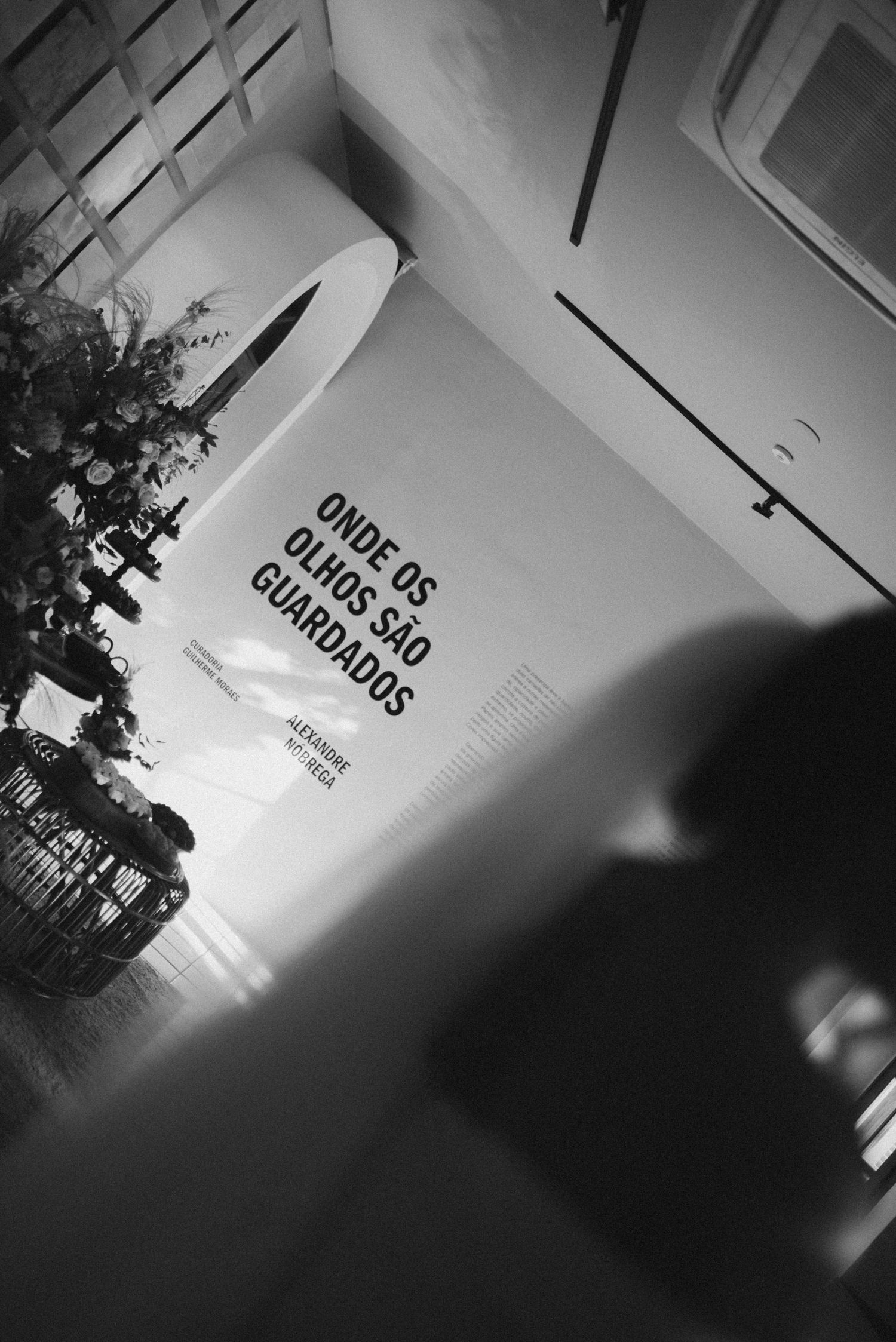 Black and white artistic shot of signage and shadows in an interior hallway.