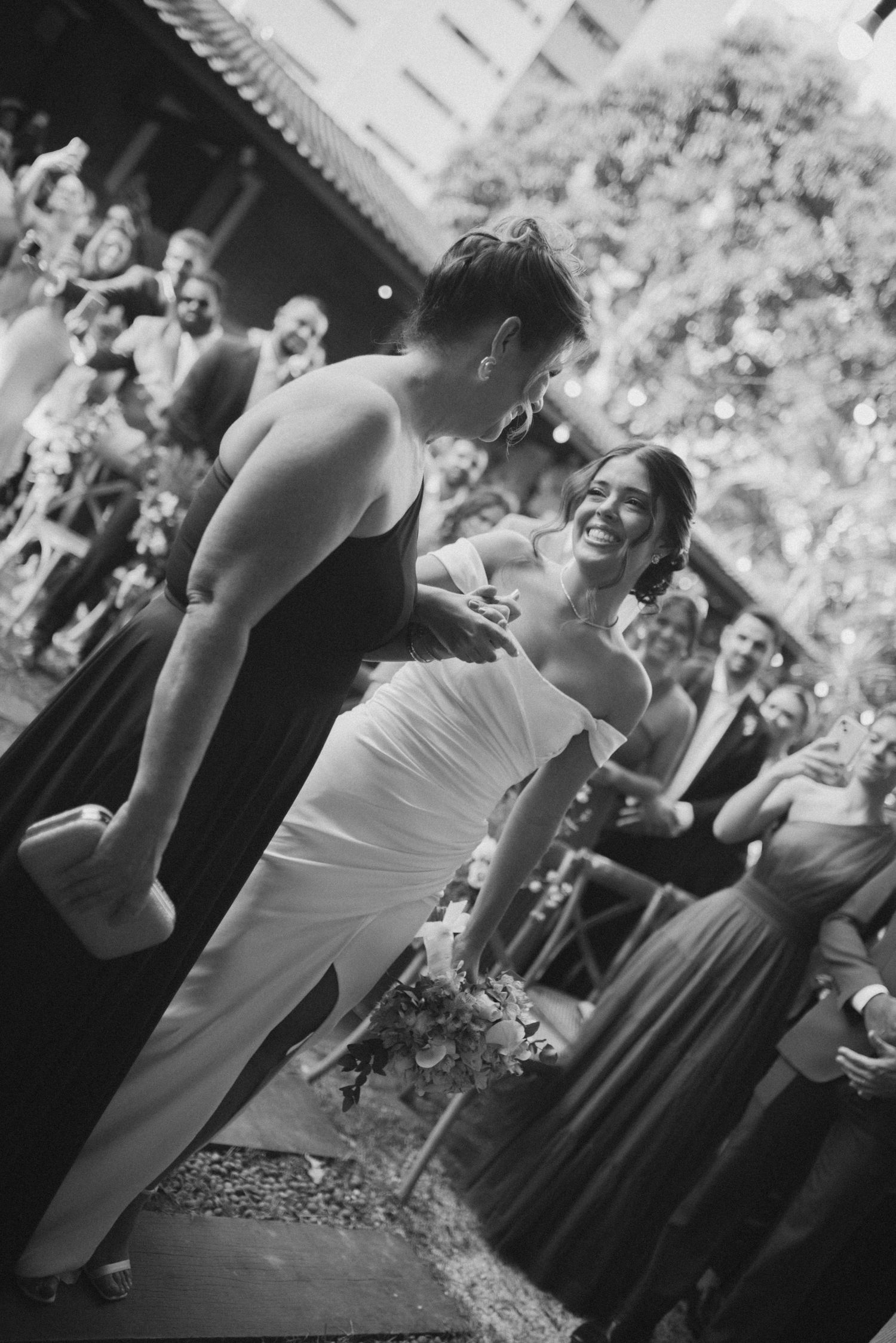 Black and white candid moment between couple during outdoor wedding reception.