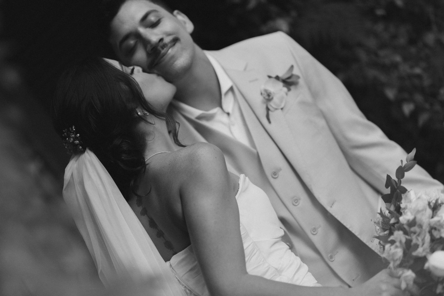 Romantic black and white portrait during outdoor garden wedding celebration.