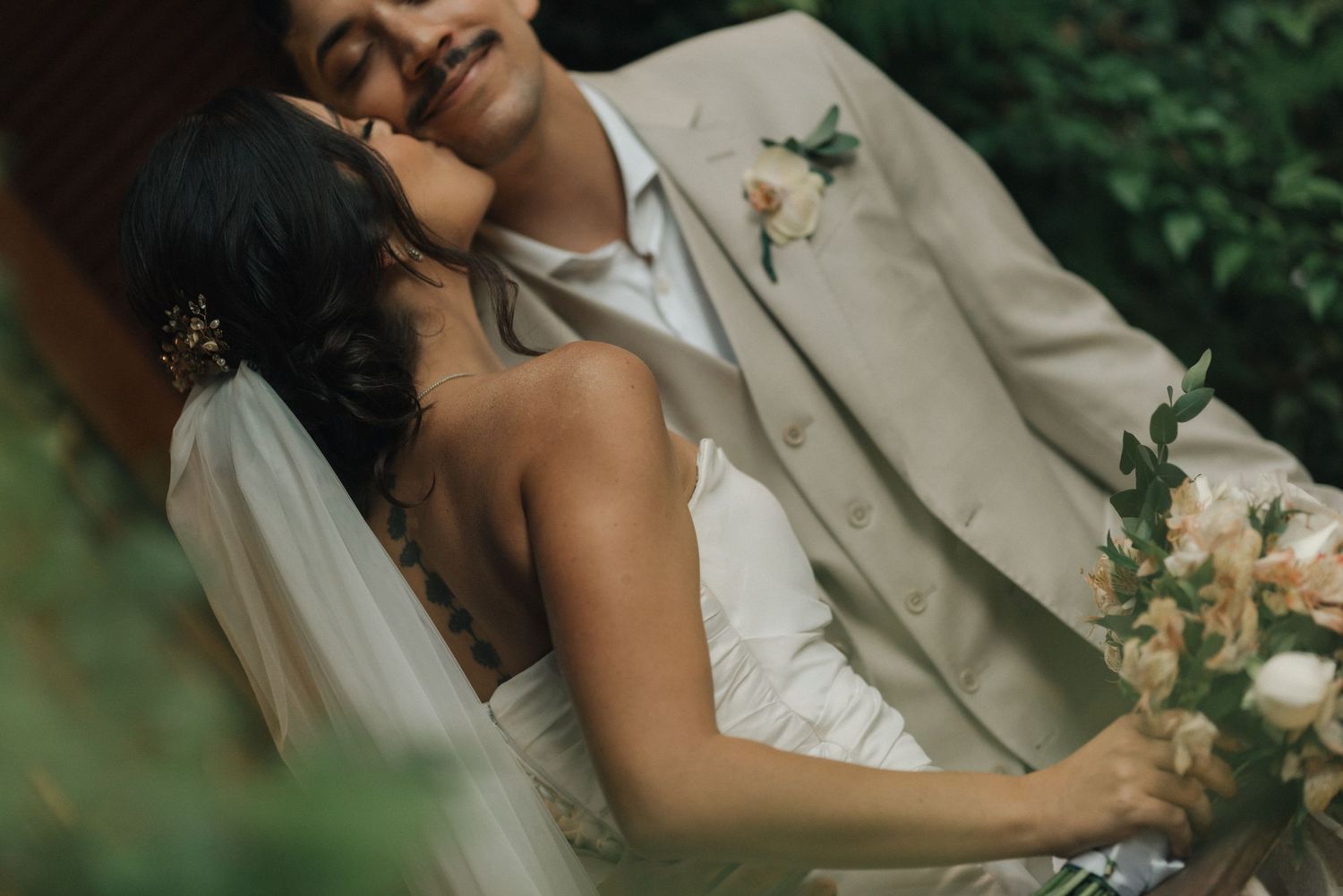 Intimate wedding moment captured between couple in natural outdoor setting.