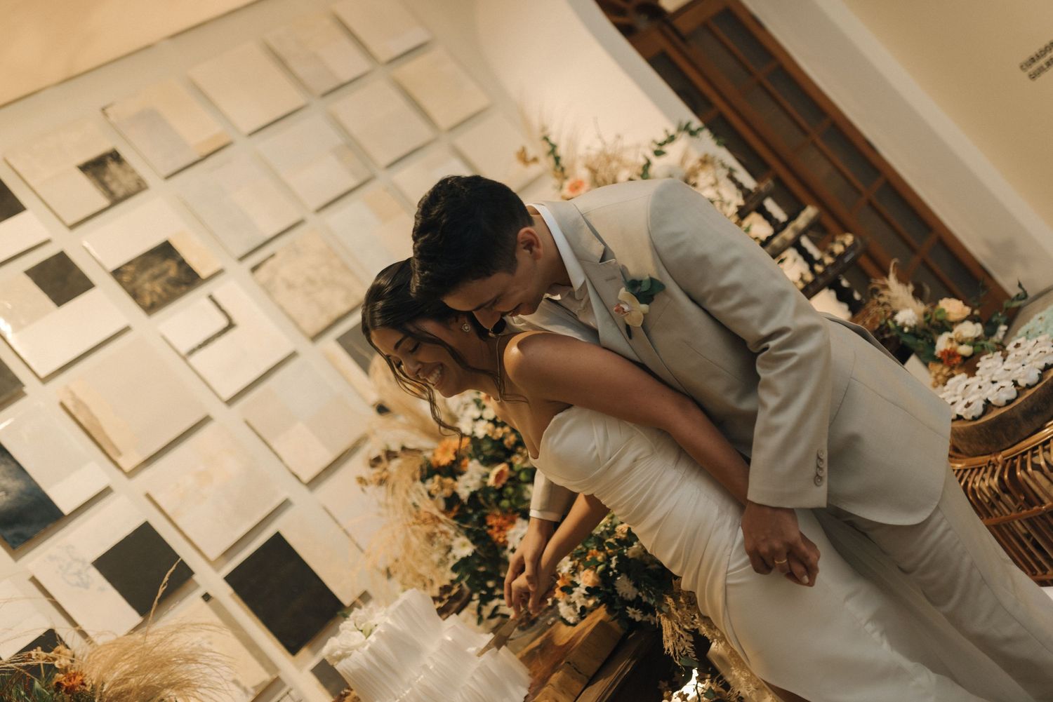 Artistic overhead shot of newlyweds sharing intimate moment on geometric floor pattern.