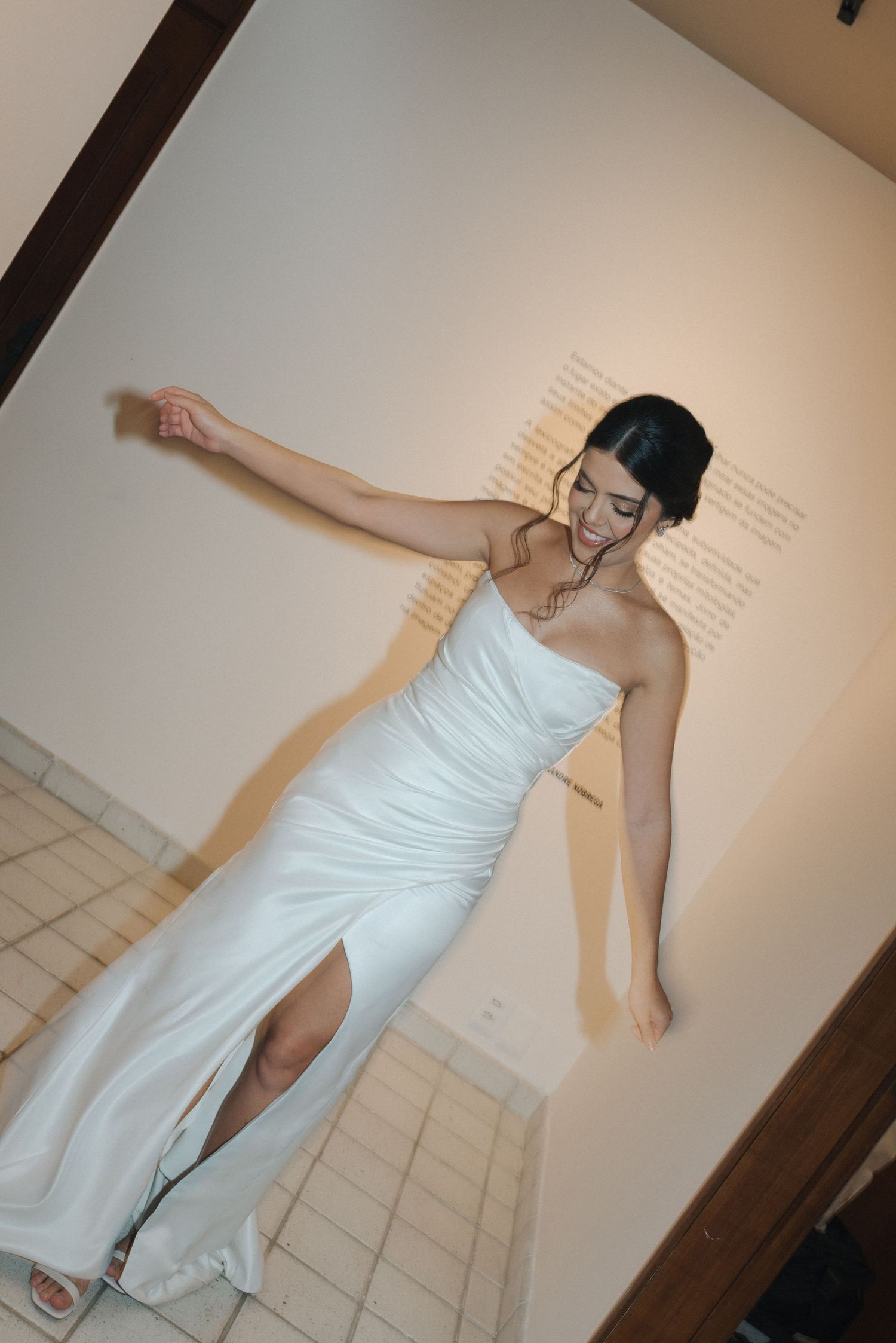 A figure strikes a dynamic pose in a form-fitting white gown with side slit.